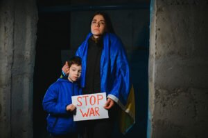 Madre ucraniana, junto a su hijo, con un cartel pidiendo el alto a la guerra