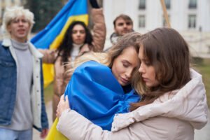 Mujeres ucranianas abrazadas y con la bandera de Ucrania